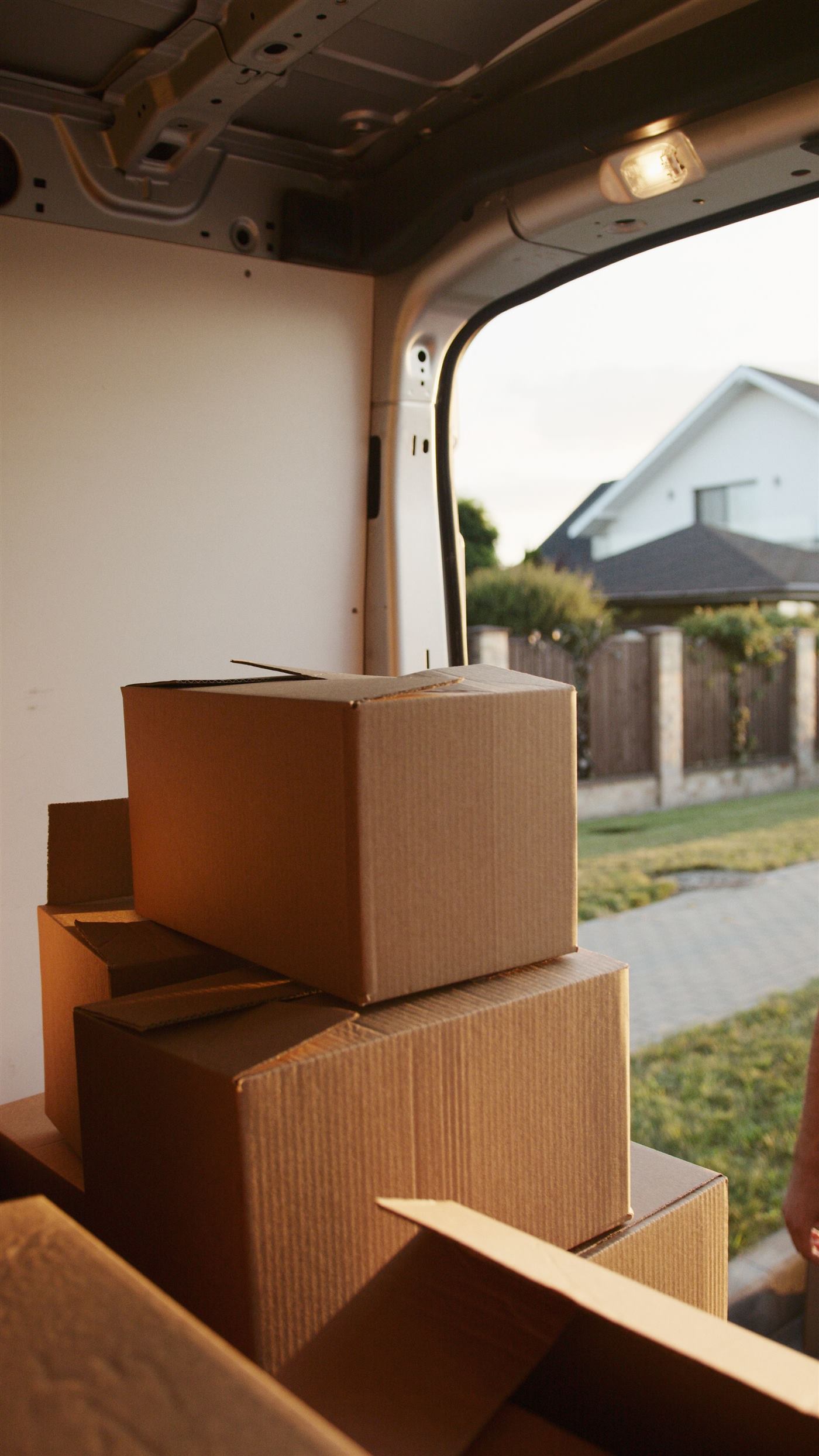 Cartons de déménagement chargés dans un véhicule utilitaire devant un immeuble